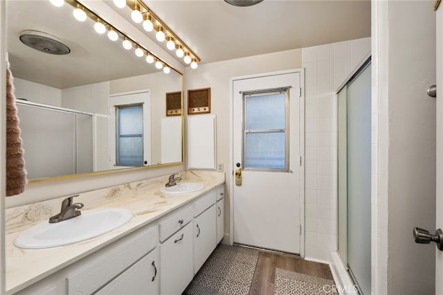 bathroom featuring a shower with door, vanity, and hardwood / wood-style flooring