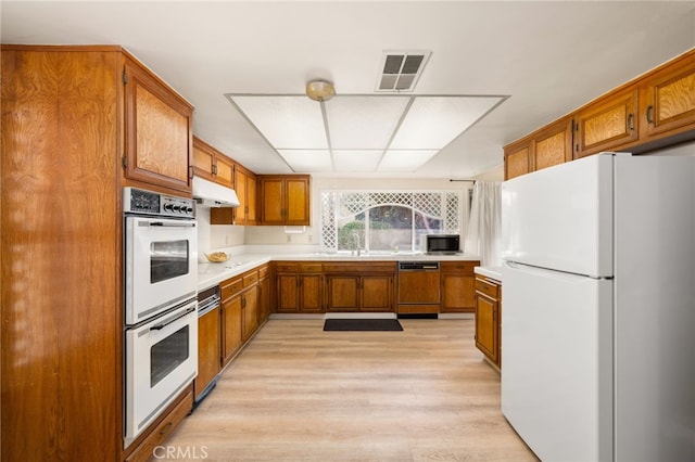 kitchen featuring sink, white appliances, and light hardwood / wood-style floors