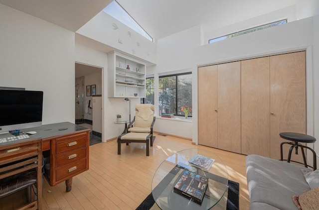 office space with a high ceiling and light hardwood / wood-style floors