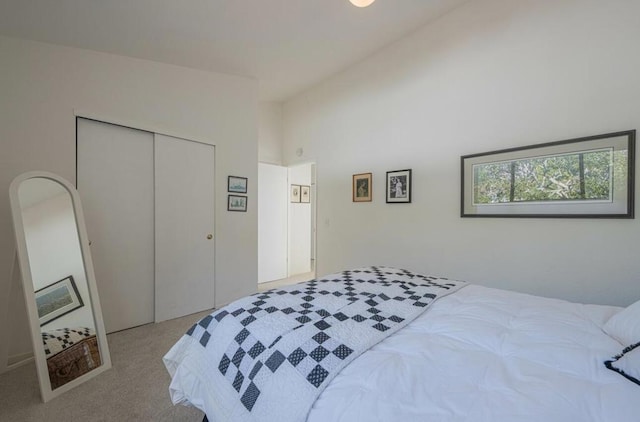 bedroom with light colored carpet, high vaulted ceiling, and a closet