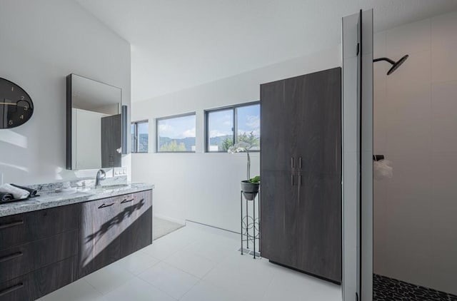 bathroom featuring tiled shower and vanity