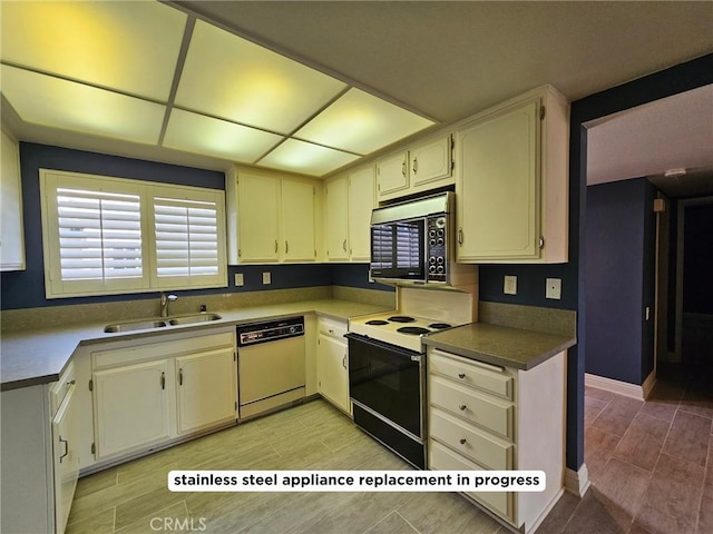 kitchen with cream cabinets, white dishwasher, sink, and electric range oven