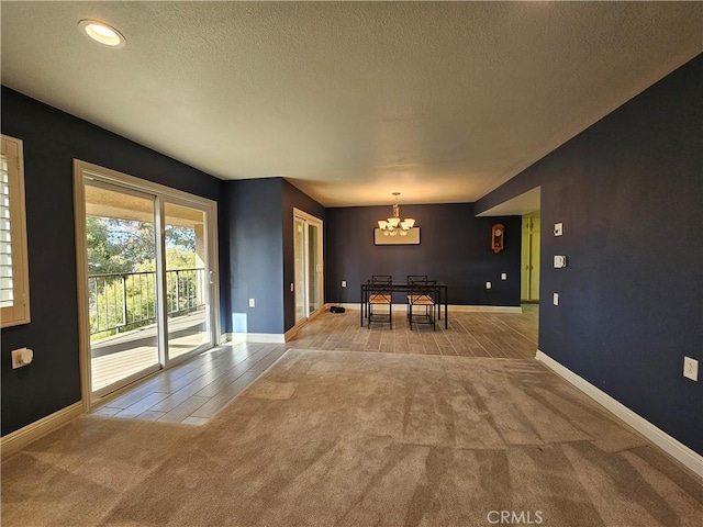 unfurnished dining area featuring light carpet, a notable chandelier, and a textured ceiling