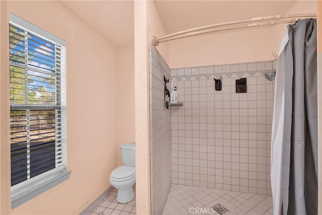 bathroom featuring a shower with curtain, tile patterned floors, and toilet