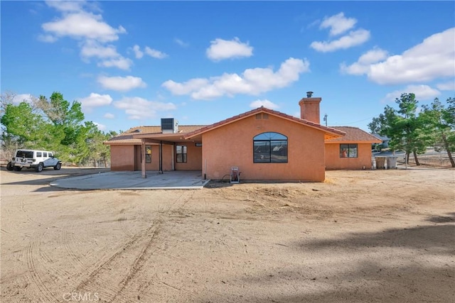 view of front of property with central AC unit and a patio