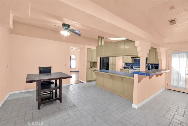 kitchen featuring a breakfast bar, a wealth of natural light, ceiling fan, and kitchen peninsula