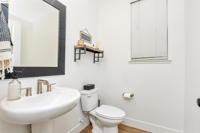 bathroom featuring toilet, sink, and hardwood / wood-style floors