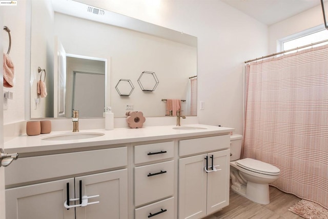 bathroom featuring walk in shower, vanity, toilet, and hardwood / wood-style floors