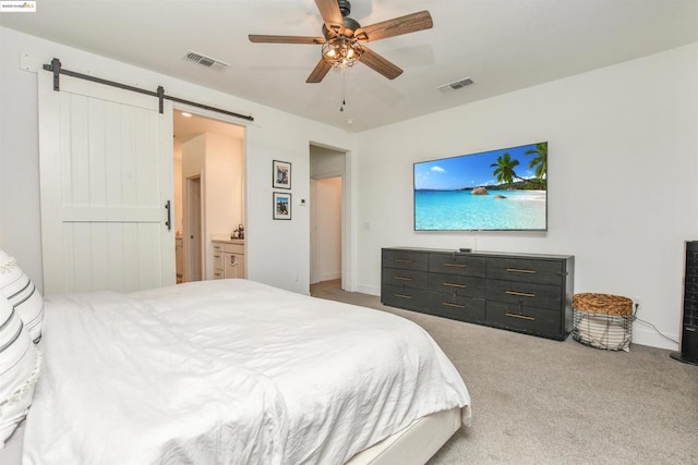 bedroom featuring light carpet, a barn door, and ceiling fan