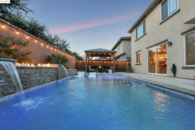 pool at dusk with a gazebo, pool water feature, a patio area, and central air condition unit