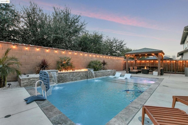 pool at dusk with pool water feature, a patio, a gazebo, and an outdoor living space with a fire pit