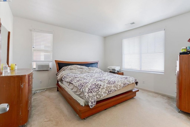 bedroom with cooling unit and light carpet