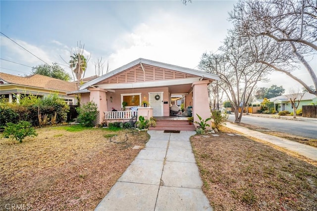 bungalow with a porch and a front lawn