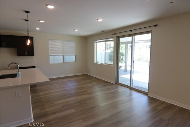 interior space featuring dark wood-type flooring, decorative light fixtures, and sink