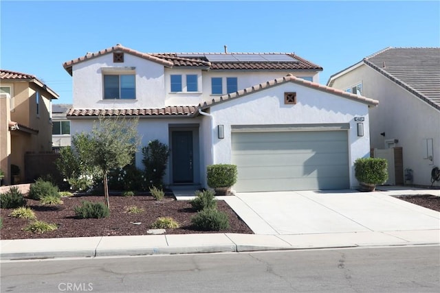 mediterranean / spanish-style home featuring a garage and solar panels