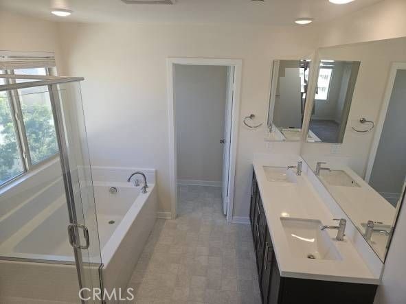 bathroom featuring vanity and independent shower and bath