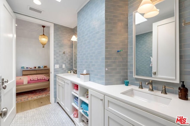 bathroom featuring vanity, tile patterned flooring, tasteful backsplash, and tile walls