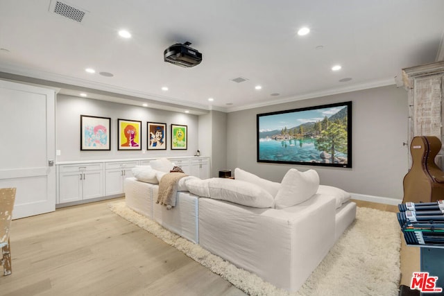 home theater featuring ornamental molding and light hardwood / wood-style floors