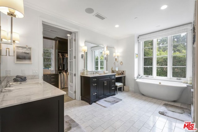 bathroom featuring crown molding, a wealth of natural light, and vanity