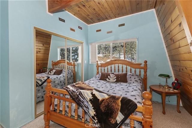 carpeted bedroom with vaulted ceiling with beams, wood ceiling, and a closet