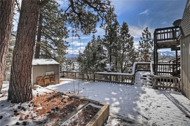 snow covered deck with a mountain view