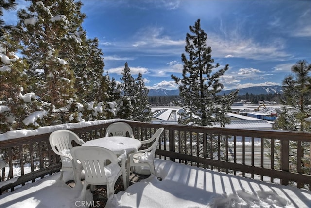 snow covered deck with a mountain view