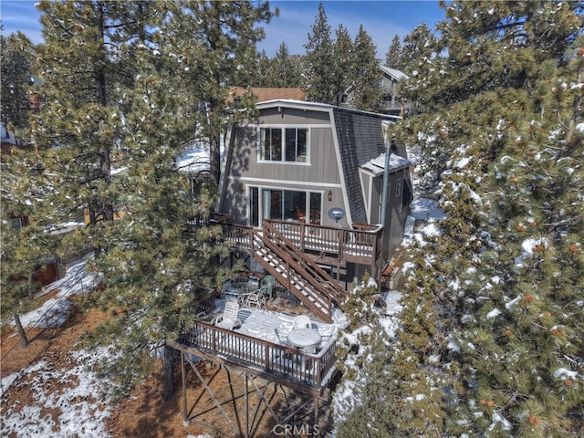 snow covered house with a wooden deck