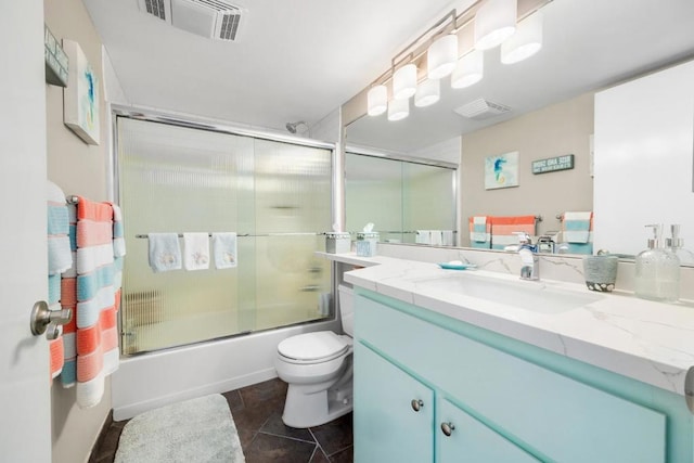 full bathroom featuring tile patterned flooring, vanity, shower / bath combination with glass door, and toilet