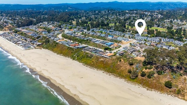 birds eye view of property with a water view and a view of the beach