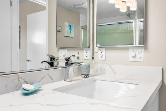 bathroom with vanity and a shower with shower door