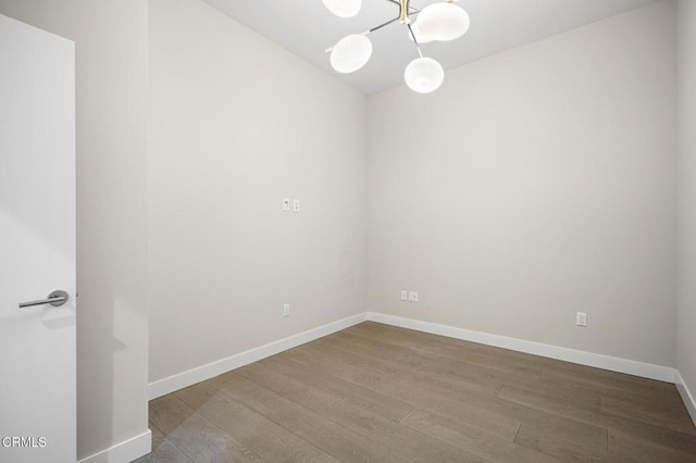 unfurnished room with hardwood / wood-style flooring and a chandelier