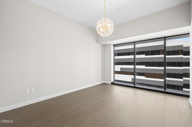 unfurnished room featuring hardwood / wood-style flooring and a chandelier