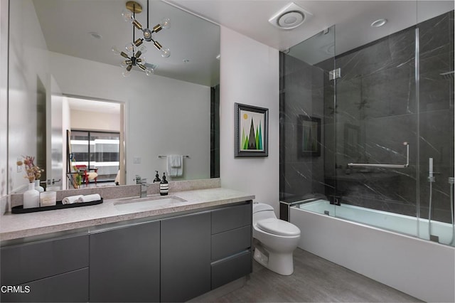 full bathroom with toilet, vanity, shower / bath combination with glass door, and hardwood / wood-style floors