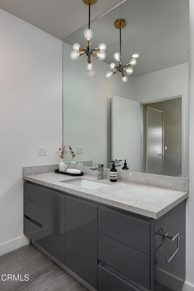 bathroom featuring vanity, hardwood / wood-style floors, and a notable chandelier