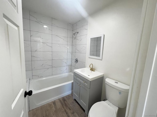 full bathroom featuring vanity, tiled shower / bath combo, wood-type flooring, and toilet