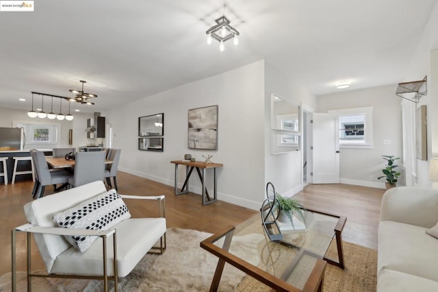 living room with an inviting chandelier and light hardwood / wood-style flooring