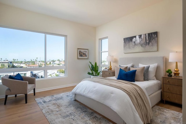 bedroom with multiple windows and light hardwood / wood-style floors