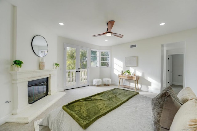 bedroom featuring french doors, access to outside, ceiling fan, a fireplace, and carpet