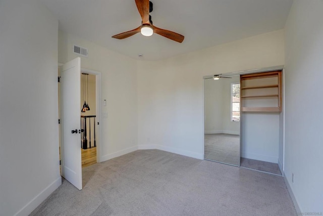 unfurnished bedroom featuring light carpet, ceiling fan, and a closet