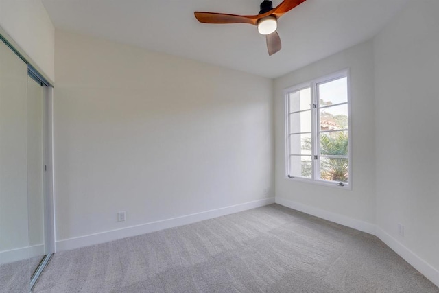 carpeted spare room featuring ceiling fan