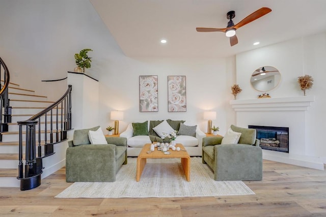 living room with ceiling fan and light hardwood / wood-style flooring