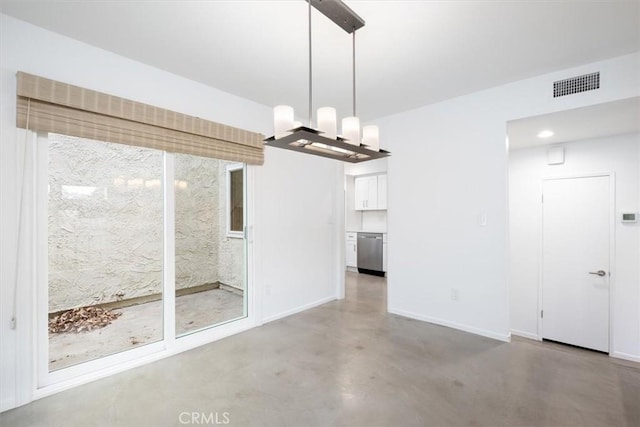 unfurnished dining area featuring concrete flooring and a chandelier