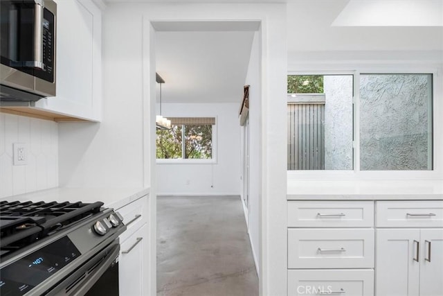 kitchen featuring an inviting chandelier, stainless steel appliances, and white cabinets