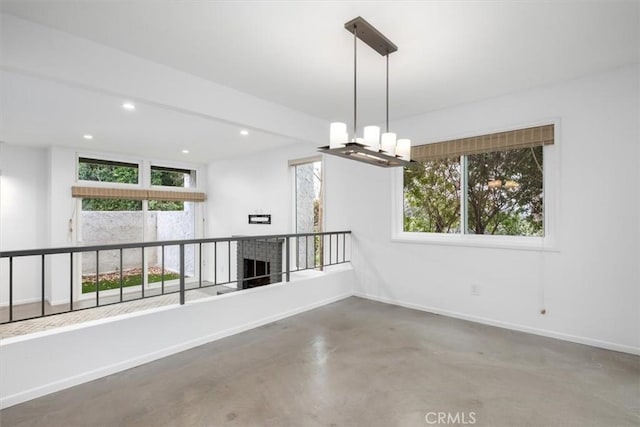 empty room with concrete flooring and a chandelier