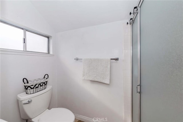 bathroom featuring lofted ceiling, toilet, and an enclosed shower