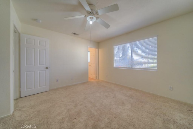 unfurnished room with ceiling fan and light colored carpet