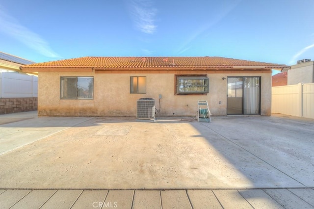 rear view of house featuring cooling unit and a patio area