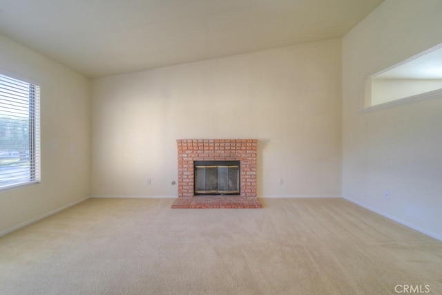 unfurnished living room featuring a brick fireplace and light colored carpet