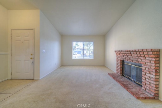 unfurnished living room with light carpet, a brick fireplace, and vaulted ceiling