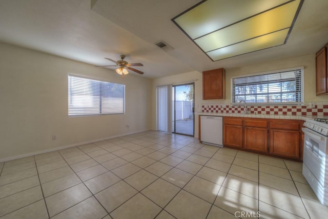 kitchen featuring sink, decorative backsplash, light tile patterned floors, ceiling fan, and white appliances